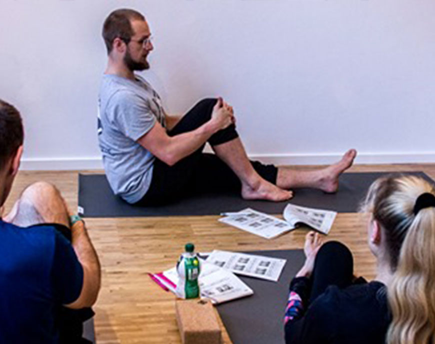 Fabian von Puttkamer leitet einen Fuß-Workshop mit Teilnehmenden auf Matten